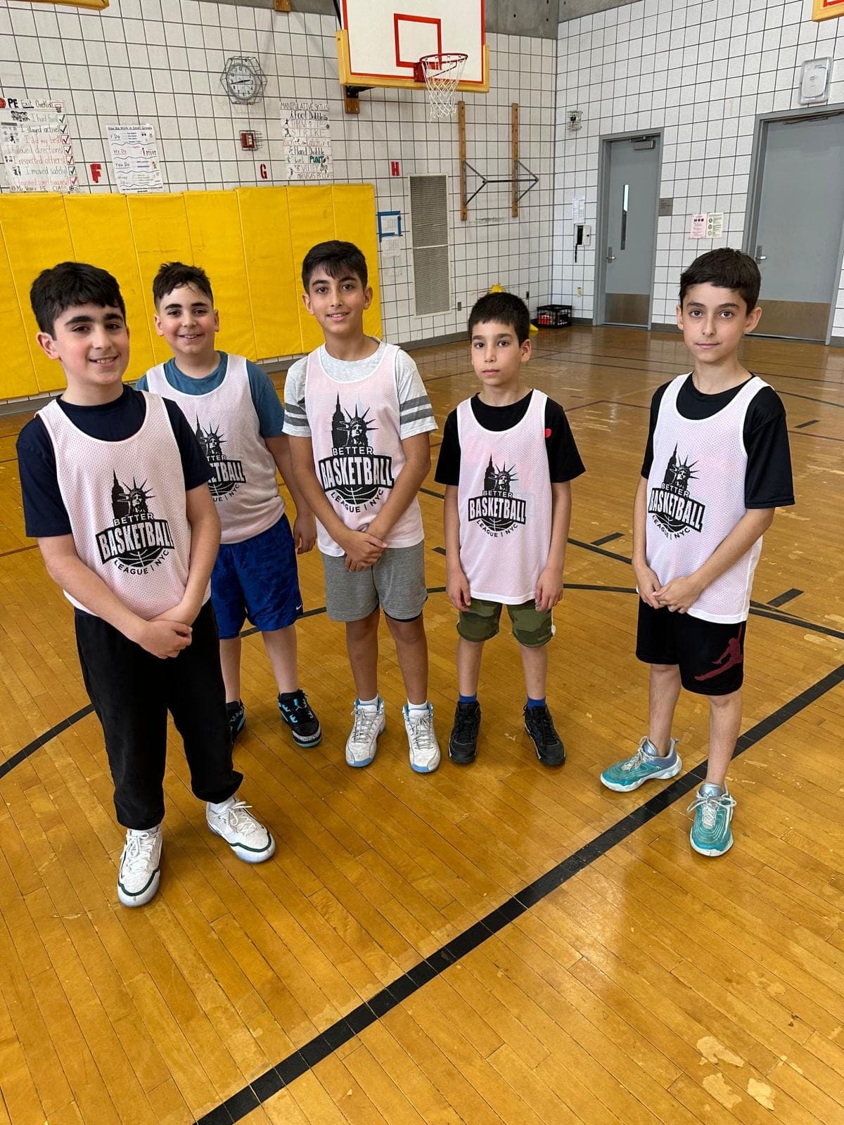 Five players in white BBL NYC pinnies standing in a row across the court