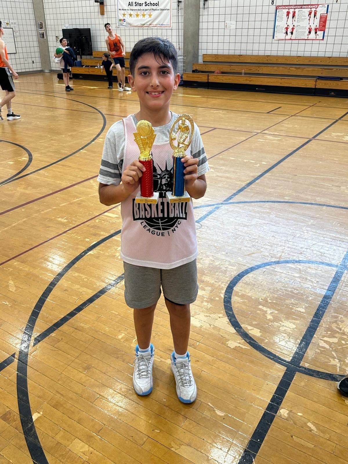 A player holding the two trophies he was awarded at the end of the season